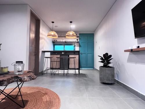 a living room with a kitchen with a blue door at Parallelo Loft Salento P2 in Salento