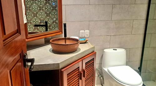 a bathroom with a basket on a counter next to a toilet at El Guayacan Retreat in Valle la Laguna