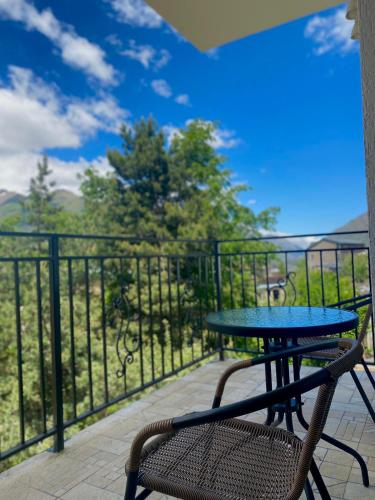 a table and a chair on a balcony with a view at Mood Hotel Kazbegi in Stepantsminda