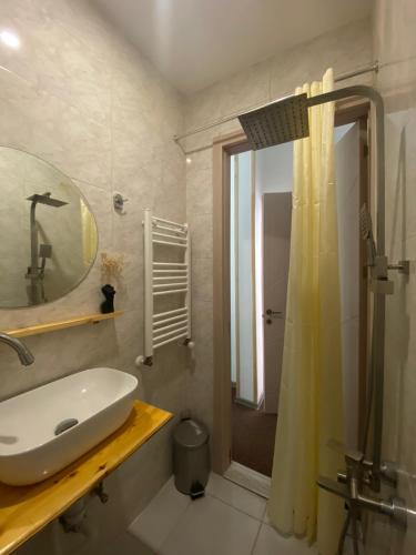 a bathroom with a sink and a mirror and a shower at Mood Hotel Kazbegi in Stepantsminda