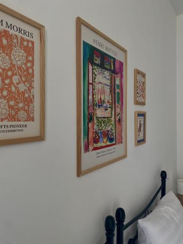 a bedroom with two framed posters on a wall at Mood Hotel Kazbegi in Stepantsminda