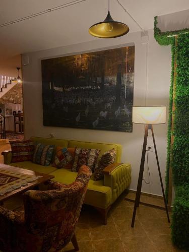 a living room with a yellow couch and a table at Mood Hotel Kazbegi in Stepantsminda