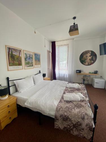 a bedroom with a large white bed and a window at Mood Hotel Kazbegi in Stepantsminda