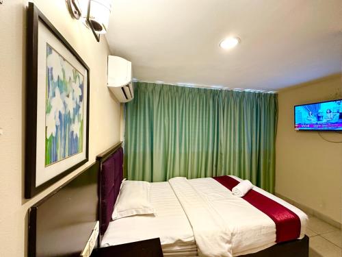 a bedroom with a bed and a green curtain at VALLEY HOTEL in Kota Kinabalu