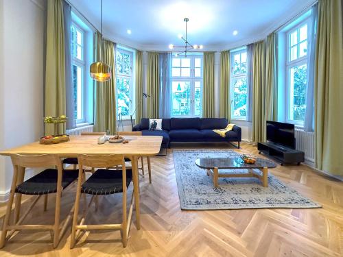 ein Wohnzimmer mit einem Tisch und einem blauen Sofa in der Unterkunft Pineblue Villas in Heringsdorf