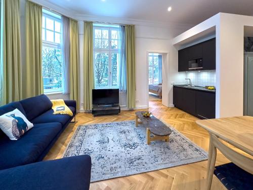 a living room with a blue couch and a table at Pineblue Villas in Heringsdorf