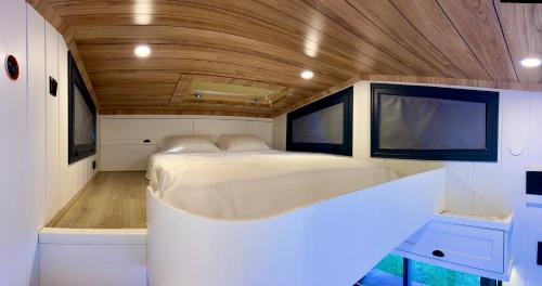 a large bed in a small room with wood ceilings at Tiny Datca in Datca