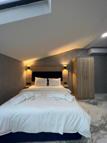 a bedroom with a large white bed with towels on it at Melissa Suite in Trabzon