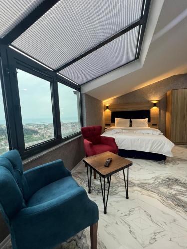 a bedroom with a bed and a couch and a table at Melissa Suite in Trabzon
