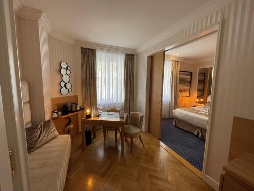 een hotelkamer met een bed, een tafel en een spiegel bij Maison LUTETIA R in Straatsburg