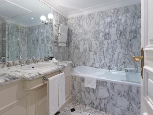 a bathroom with a sink and a tub and a toilet at Althoff Hotel Villa Belrose in Saint-Tropez