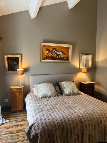 Saint-AndiolにあるHaras Saint Estèveのベッドルーム1室(ランプ2つ、絵画付)