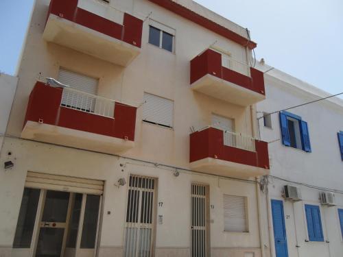 un bâtiment avec portes et fenêtres rouges et bleues dans l'établissement Case Vacanza Lampedusa, à Lampedusa