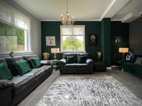 sala de estar con sofá y paredes verdes en Loch Lomond Mews, en Balloch