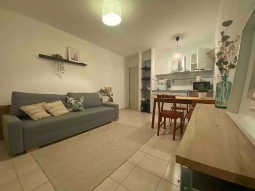 a living room with a couch and a table at cosy appartement avec parking au centre et port in Toulon
