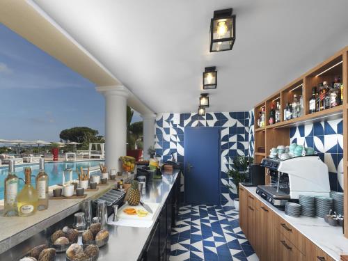 a restaurant with a buffet line with a pool in the background at Althoff Hotel Villa Belrose in Saint-Tropez