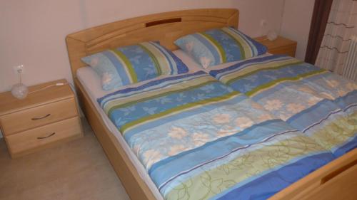 a bed with a wooden headboard and a night stand at Haus Ferdinand in Leutasch