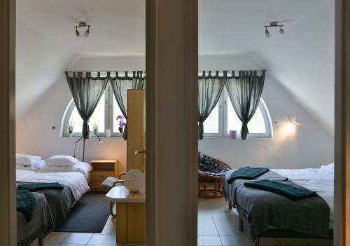 a bedroom with two beds and two windows at VillaBeach 50m from the beach in Fonyód