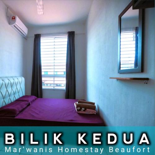 ein Schlafzimmer mit einem lila Bett und einem Spiegel in der Unterkunft Mar'Wanis Homestay Beaufort Sabah in Beaufort