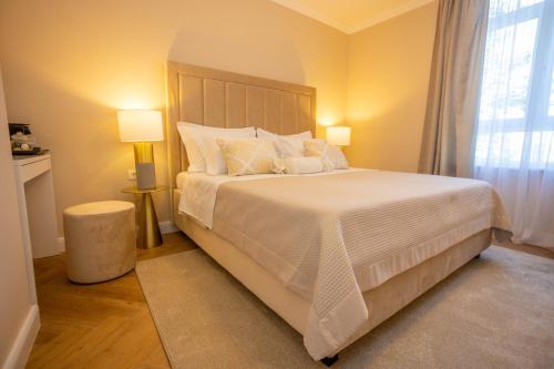 a bedroom with a large bed with white sheets and pillows at City and Style Luxury Rooms Split in Split