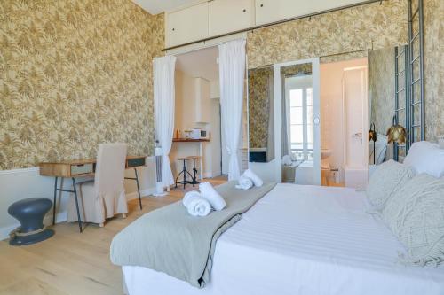 een slaapkamer met een groot wit bed en een bureau bij "La Casa Mare" Charmant Studio avec Vue Mer, Plage in Menton