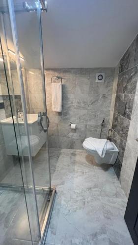 a bathroom with a shower and a toilet and a sink at Melissa Suite in Trabzon