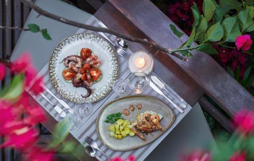 a table with two plates of food and a candle at Pousada Jeribá in Jericoacoara