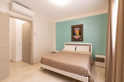 a bedroom with a bed and a painting on the wall at Appartamento A Pigna in Balestrate