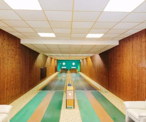 een lege bowlingbaan in een gebouw met houten wanden bij Gasthaus Zum goldenen Löwen in Finkenbach