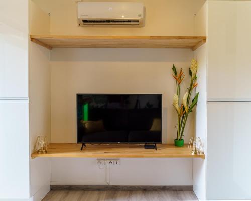a flat screen tv sitting on a shelf in a living room at Studio Carambole by Sweety Stay in Schœlcher