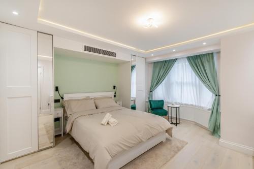 a bedroom with a bed and a desk and a window at Entire Garden Flat with Parking - Portobello Road in London
