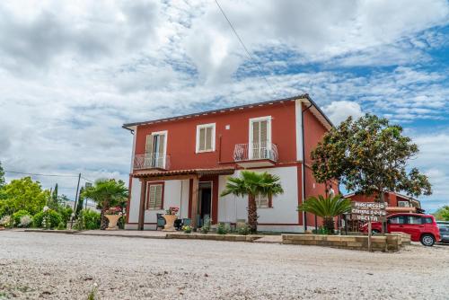 ポンテ・ガレリアにあるAgriturismo il Casaleの道路脇の赤白家屋