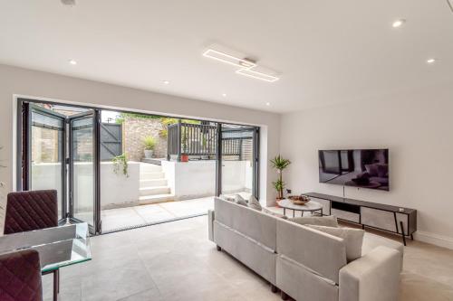 a living room with a couch and a tv at Entire Garden Flat with Parking - Portobello Road in London