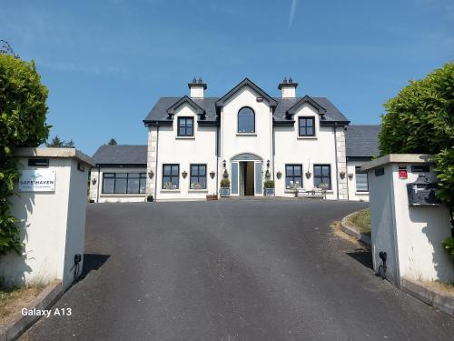 a large white house with a driveway at Safe Haven - Luxury Family Accommodation in Carlingford