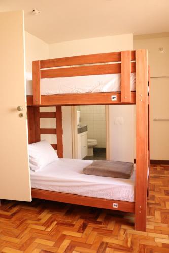 two bunk beds in a room with a wooden floor at Nuh Hostel - Lourdes in Belo Horizonte