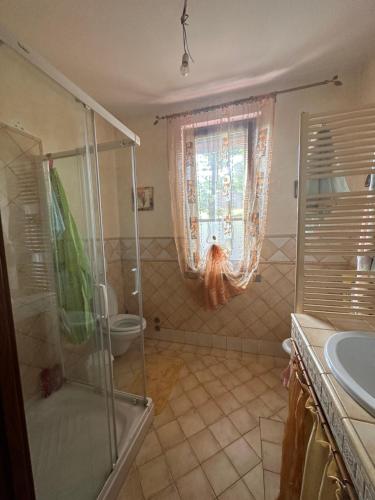 een badkamer met een douche, een toilet en een raam bij Peaceful and near town in Terranuova Bracciolini