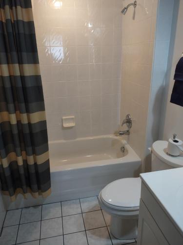 a bathroom with a tub and a toilet and a sink at The King George Inn in Cobourg