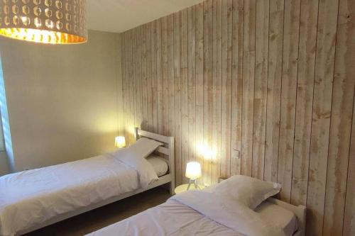 MorthemerLes Nénuphars de la Chalette的一间有两张床和一盏枝形吊灯的卧室