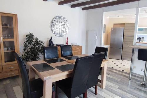 une salle à manger avec une table en bois et des chaises noires dans l'établissement Les Nénuphars de la Chalette, à Morthemer
