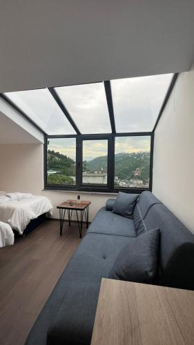 a living room with a couch and a large window at Melissa Suite in Trabzon