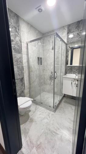 a bathroom with a shower and a toilet and a sink at Melissa Suite in Trabzon
