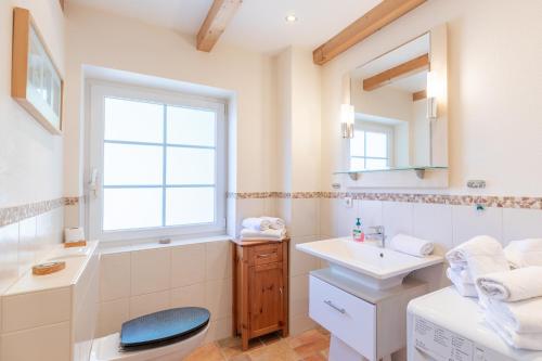 a white bathroom with a sink and a window at Haus zu den Halligen in Bredstedt