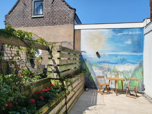 a mural on the side of a house with a table and chairs at Huys van Leyden in Leiden