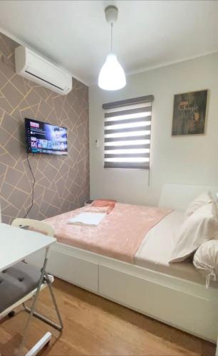 a bedroom with a bed with a desk and a window at Chesya's Guesthouse BSD City in Tangerang