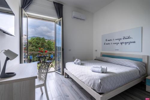 a bedroom with a bed and a large window at Ammare Bed & Breakfast in Marina di Camerota