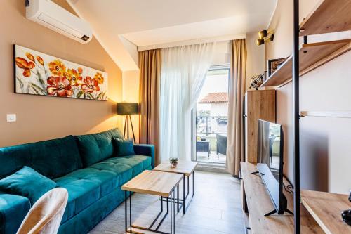 un soggiorno con divano blu e tavolo di Apartmani Tanita a Kaštela (Castelli)