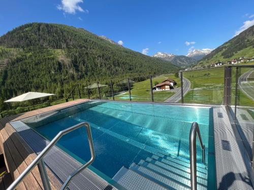 a swimming pool with a view of a mountain at Naturhotel Tandler in Sankt Jakob in Defereggen
