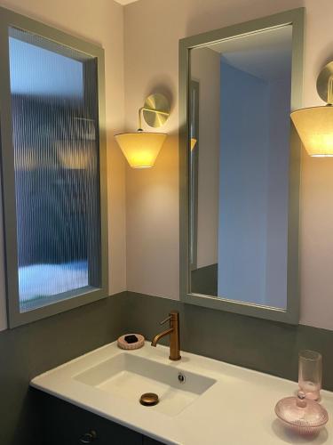 une salle de bain avec un lavabo et un miroir dans l'établissement La Maison, à Cannes