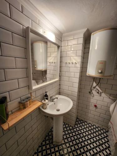 a bathroom with a sink and a mirror at Şehrin ortasında sakin konaklama in Izmir