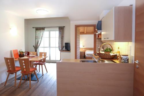 cocina y sala de estar con mesa y sillas en Waldthalerhof, en Monticolo